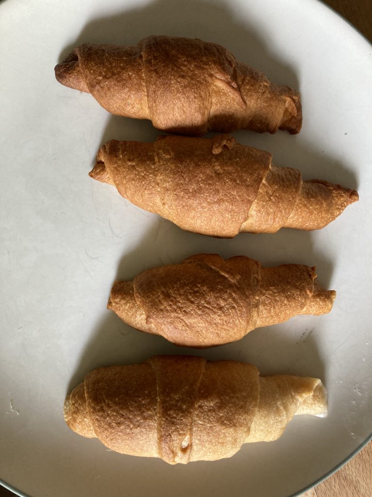 Crescent Rolls on a plate.  Most cooked (top) roll was furthest down in the cooking tube, away from the handle.